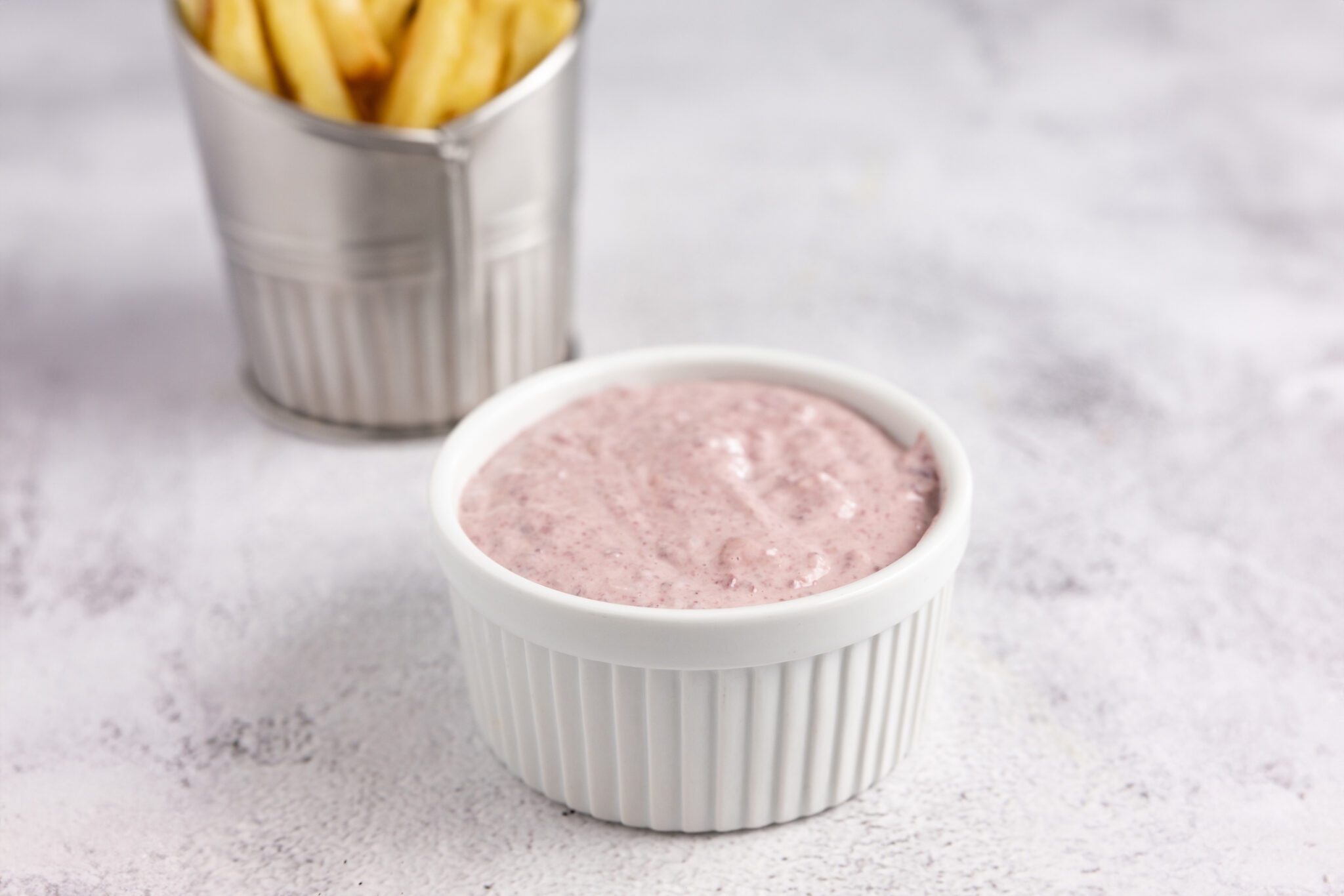 Kalmata Aioli in a white ceramic bowl with a side of french fries